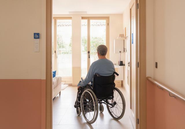 Persona en silla de ruedas entrando en una vivienda adaptada y luminosa en Figueres